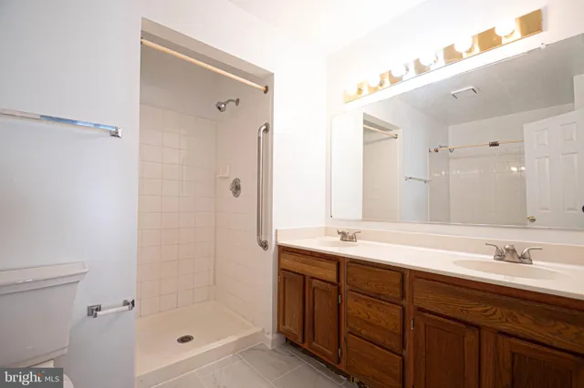 a bathroom with a shower sink vanity granite and toilet