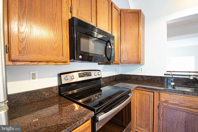a kitchen with wooden cabinets and a stove top oven