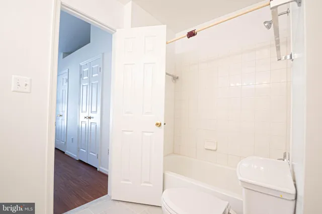 a bathroom with a bathtub shower sink vanity and toilet