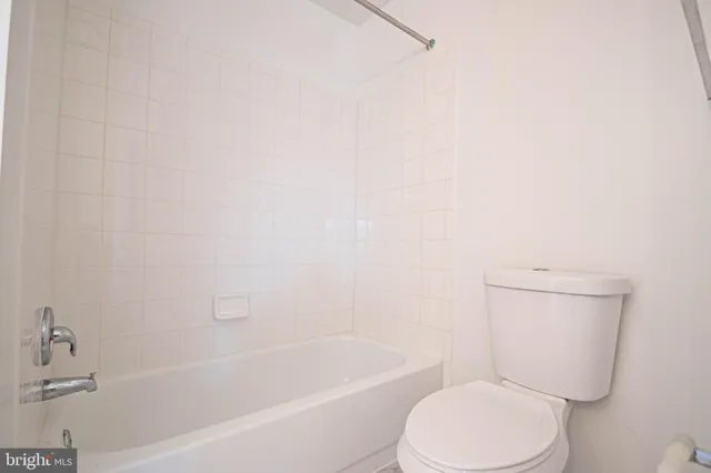 a white toilet and tub sitting next to a white cabinet