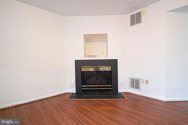 a living room with a fireplace and wooden floor