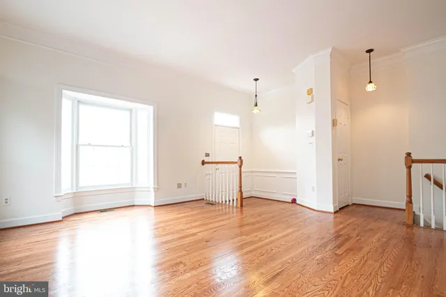 a view of empty room with wooden floor and window