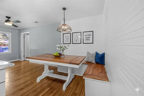 a view of a room with wooden floor and ceiling fan