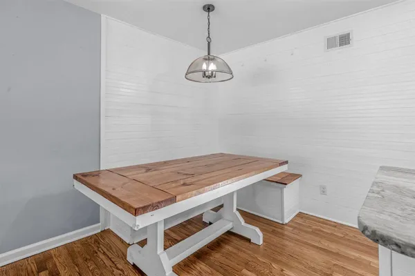 a room with pool table and wooden floor