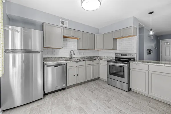 a kitchen with granite countertop white cabinets and white appliances