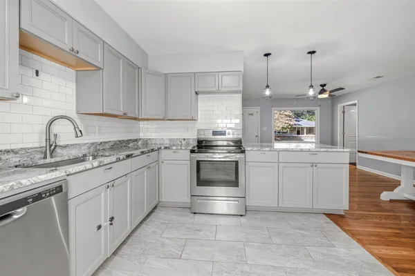 a kitchen with appliances a sink and cabinets