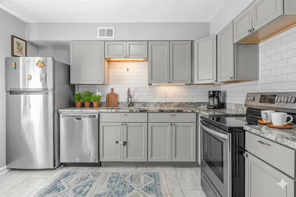 a bathroom with a granite countertop sink and washing machine