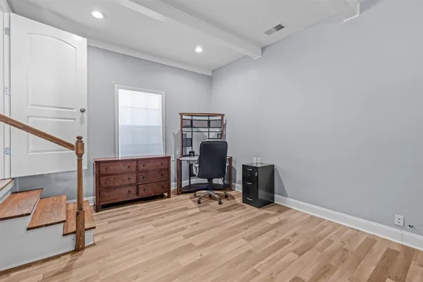 a view of an empty room with window and wooden floor