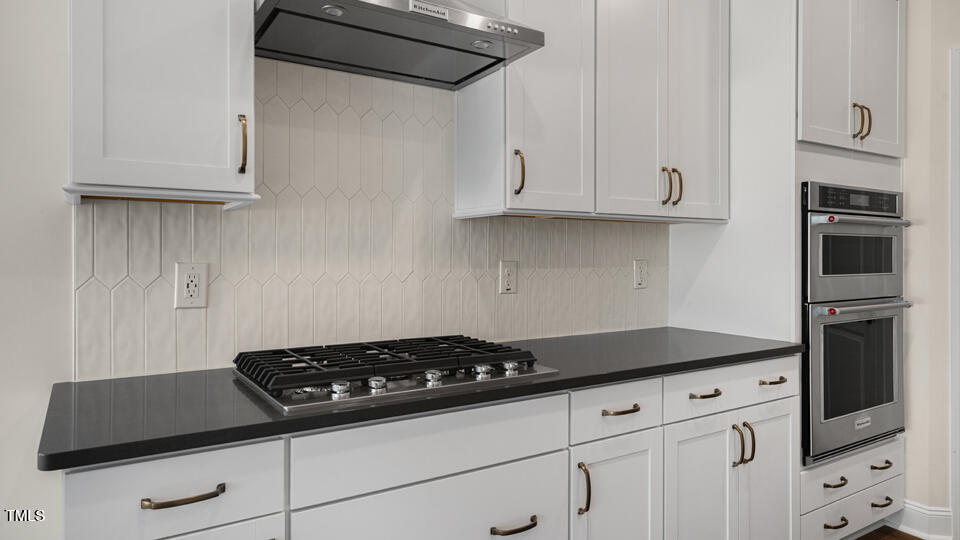 154 Red Jasper Way Clayton, NC 27520 - Photo 9 of 33 a kitchen with white cabinets and a stove