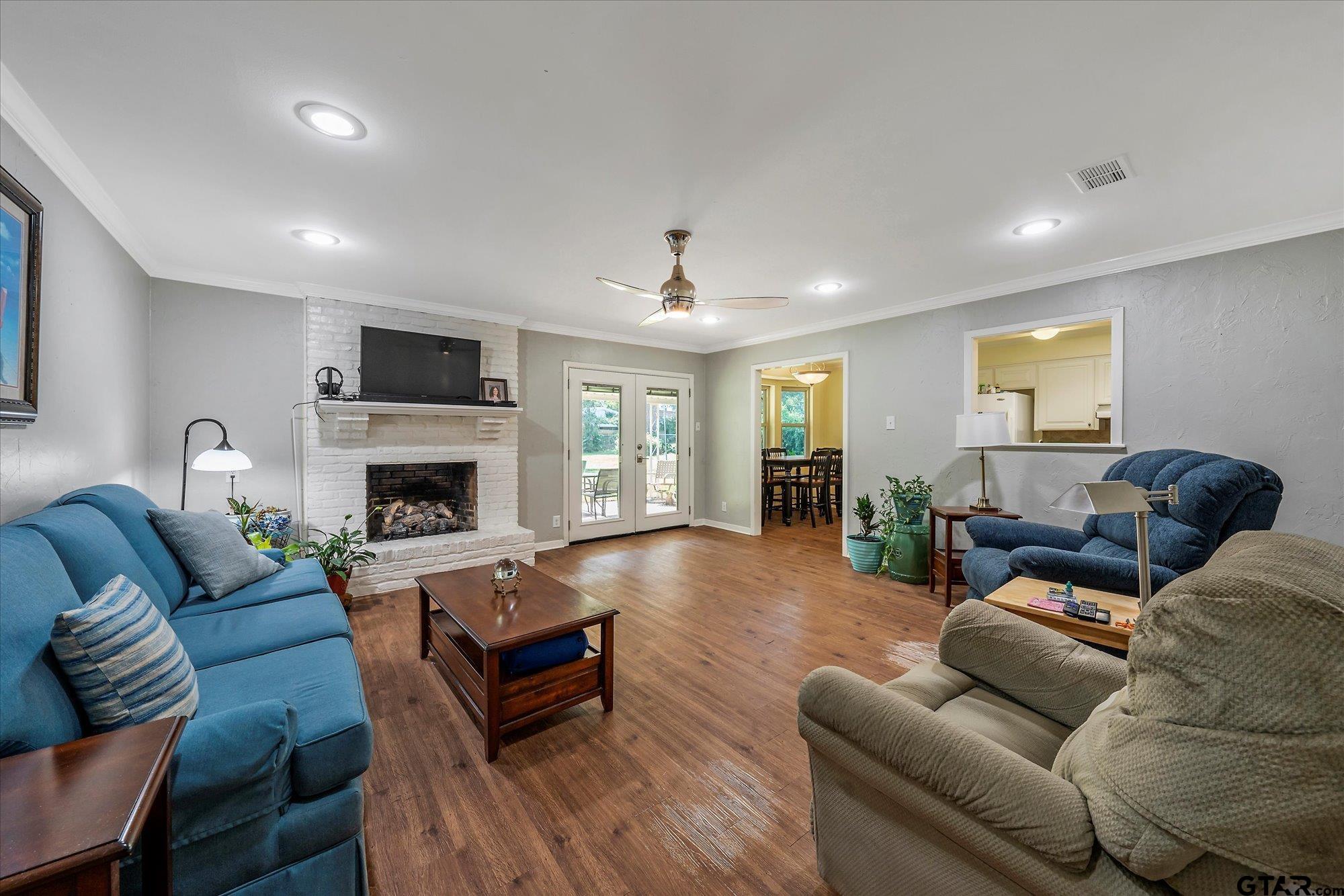 3724 Pollard Drive Tyler, TX 75701 - Photo 9 of 28 a living room with furniture a fireplace and a flat screen tv