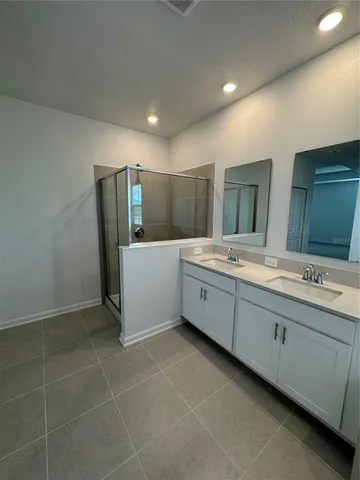 a bathroom with a double vanity sink and mirror