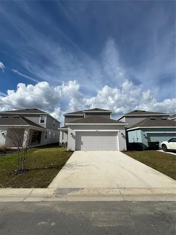 a view of house with yard and sitting area