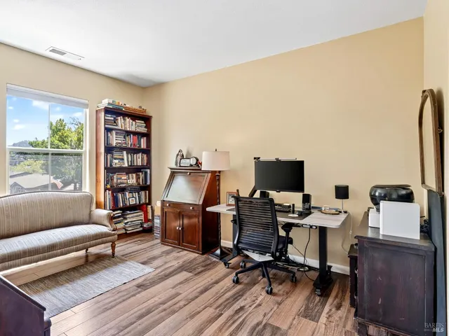 a view of a workspace with furniture and a window