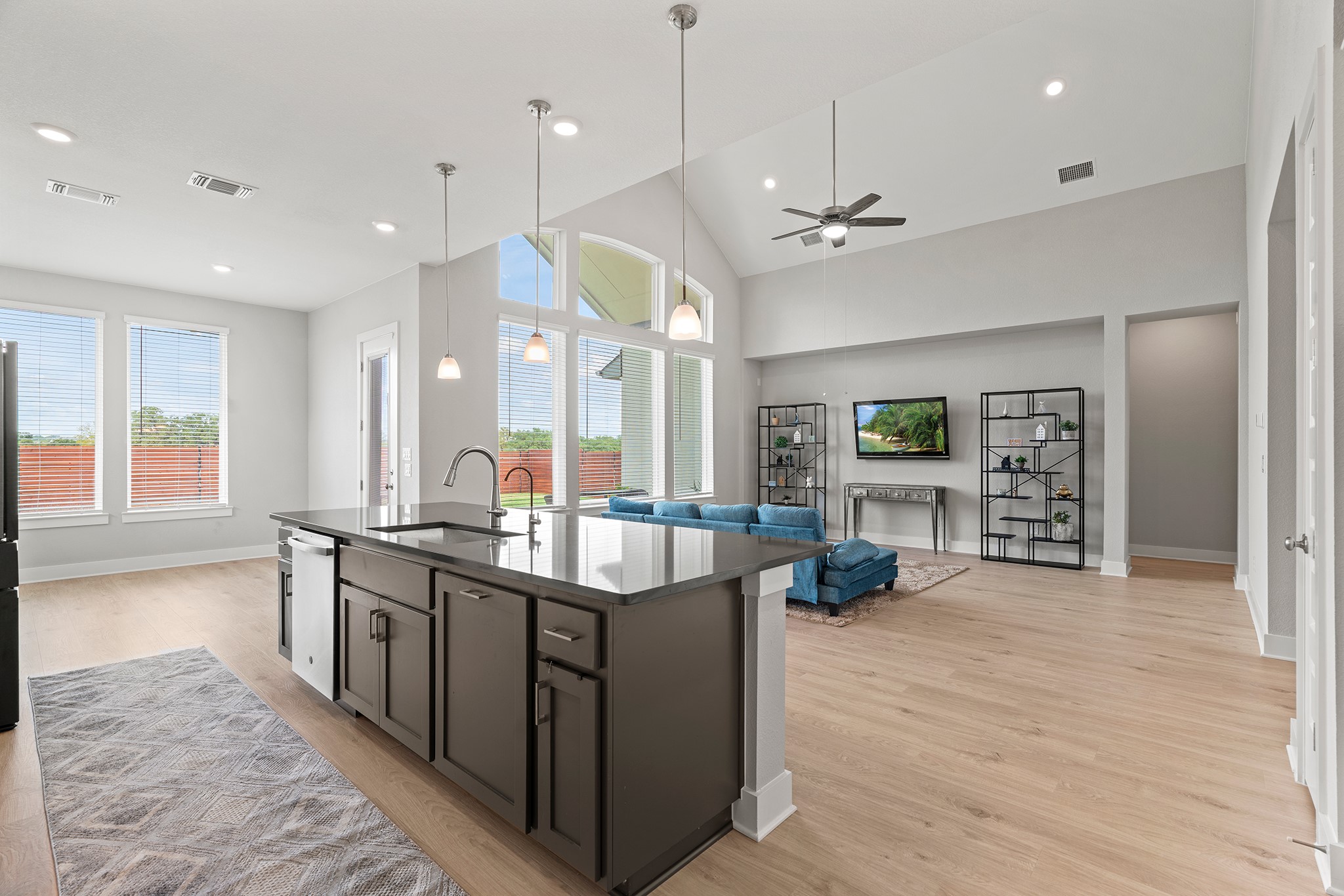 2112 Tobiano Trace Georgetown, TX 78633 - Photo 40 of 40 Kitchen featuring open floor plan, decorative light fixtures, light wood finished floors, a kitchen island with sink, and a ceiling fan