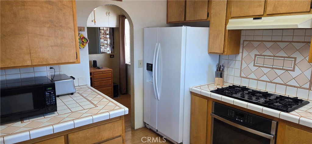 62323 Mars Drive Joshua Tree, CA 92252 - Photo 4 of 26 a kitchen with stainless steel appliances granite countertop a stove and a refrigerator