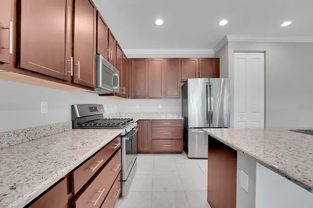 a kitchen with stainless steel appliances granite countertop refrigerator sink and stove