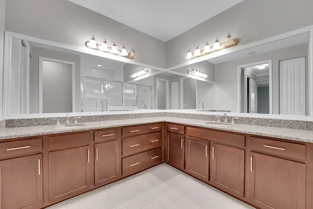 a bathroom with double vanity and a large mirror