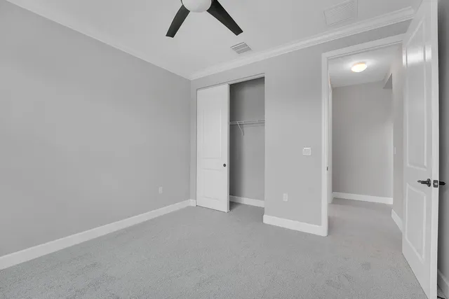 an empty room with closet and windows