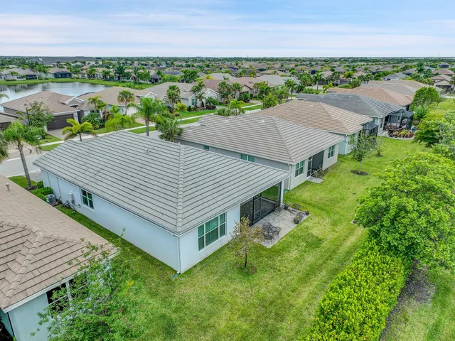 an aerial view of a house with big yard and large trees