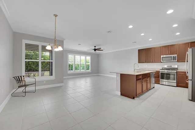 a kitchen with stainless steel appliances granite countertop a stove a sink a oven with a dining table and chairs