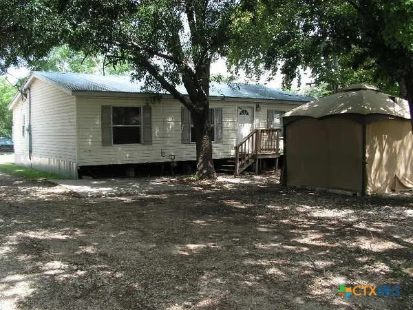 a backyard of a house with table and chairs
