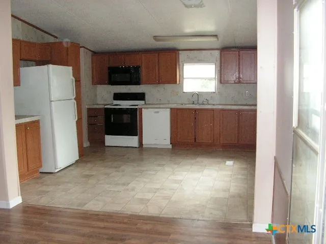 a kitchen with a refrigerator and a stove