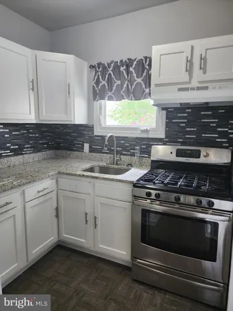 a kitchen with granite countertop cabinets stainless steel appliances and a sink