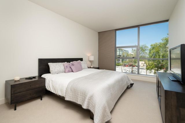 a bedroom with a bed and large window