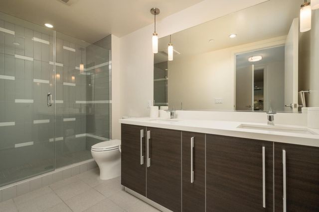 a bathroom with a double vanity sink toilet and a mirror