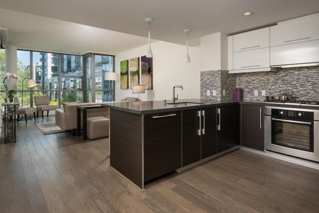 a kitchen with stainless steel appliances granite countertop a stove a sink and a microwave