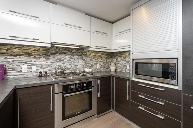 a kitchen with stainless steel appliances granite countertop a stove and a microwave