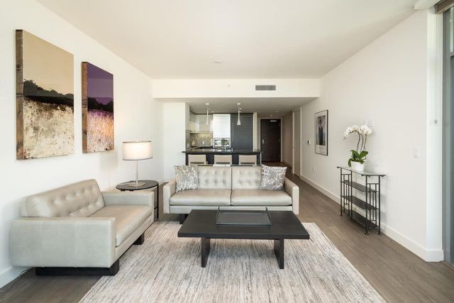 a living room with furniture a rug and a table