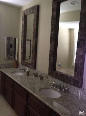 a bathroom with a double vanity sink and a mirror