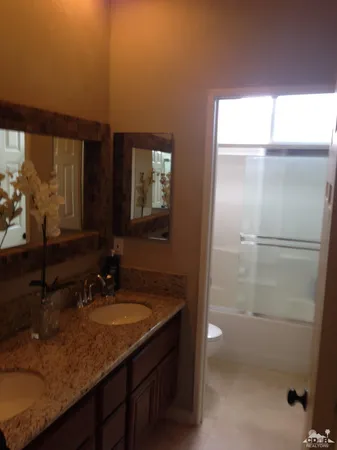 a bathroom with a sink vanity granite and a mirror