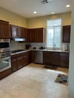 a kitchen with stainless steel appliances granite countertop a sink and a stove