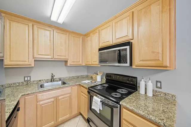 a kitchen with granite countertop a stove sink and cabinets