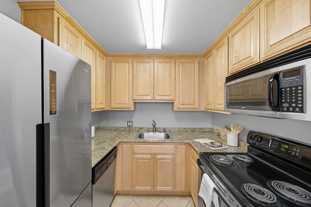 a kitchen with stainless steel appliances granite countertop a stove a sink and a microwave