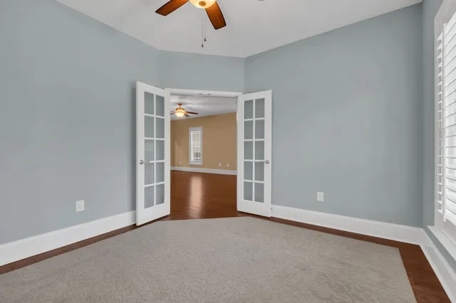 an empty room with closet and windows