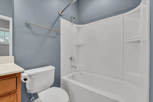 a white toilet and tub sitting next to a shower