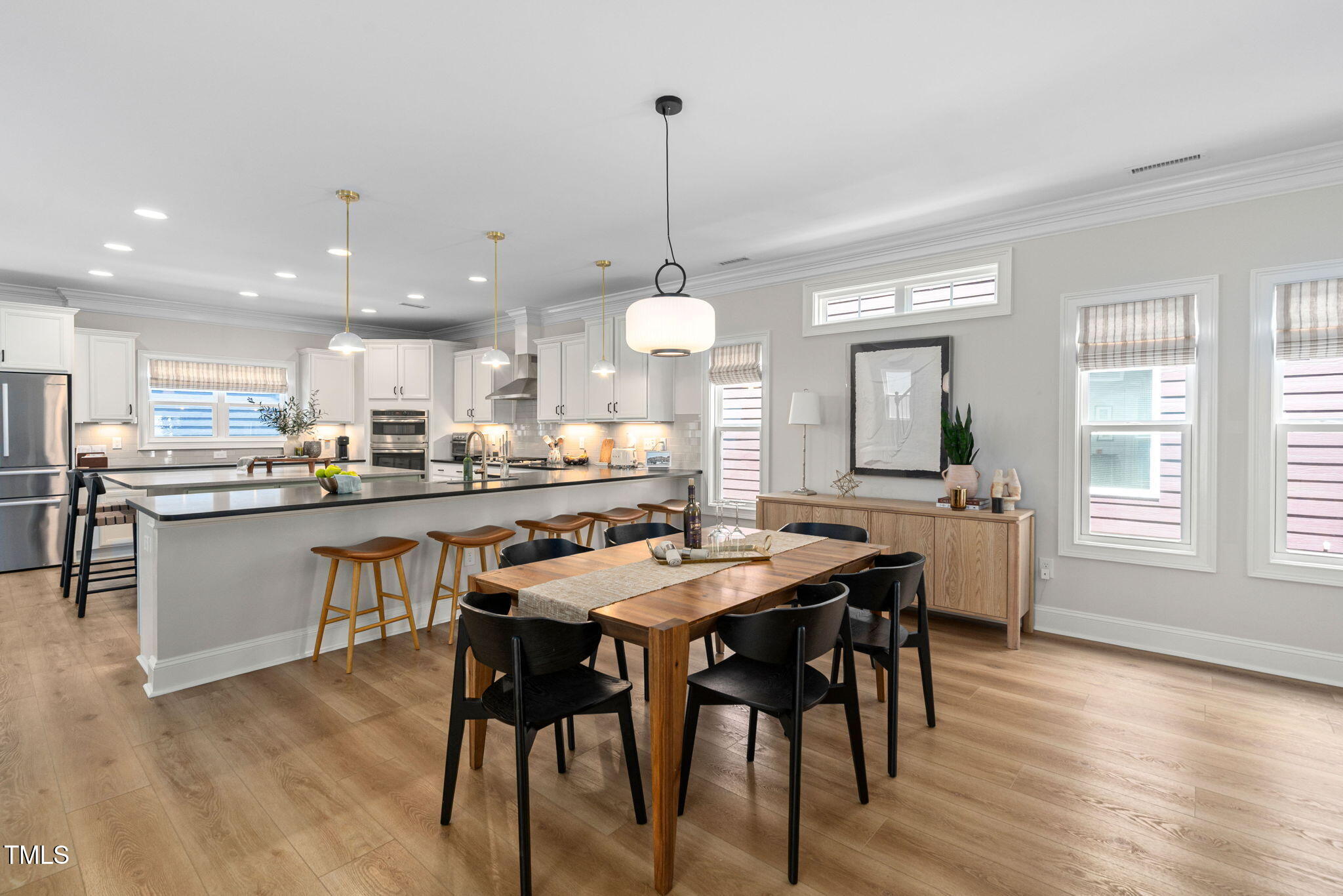 1344 Brown Velvet Lane Apex, NC 27523 - Photo 16 of 63 a kitchen with stainless steel appliances a dining table chairs stove and wooden floor