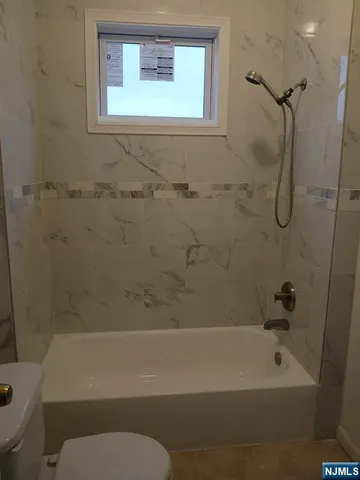 a bathroom with a toilet and a bath tub
