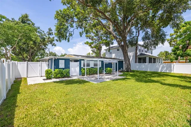 a view of a house with backyard and a tree