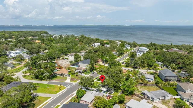 an aerial view of residential houses with outdoor space and trees