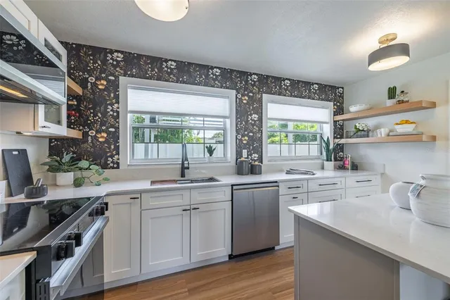 a kitchen with a sink a stove and cabinets