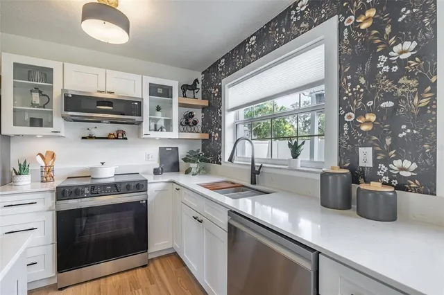 a kitchen with stainless steel appliances white cabinets and a refrigerator
