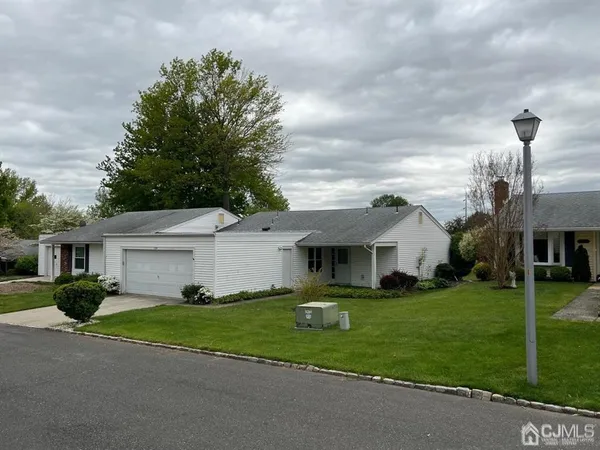 a front view of a house with a garden and trees