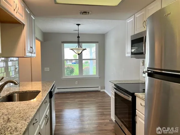a kitchen with stainless steel appliances granite countertop a sink a stove and a refrigerator