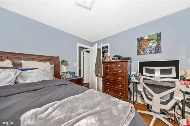 a bedroom with a bed and a flat tv screen on dresser