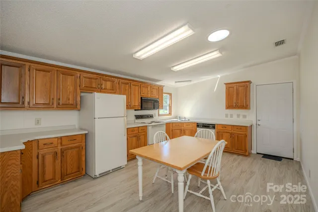 a kitchen with a table chairs refrigerator and cabinets
