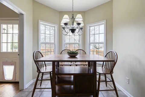 a dining room with furniture a chandelier and wooden floor